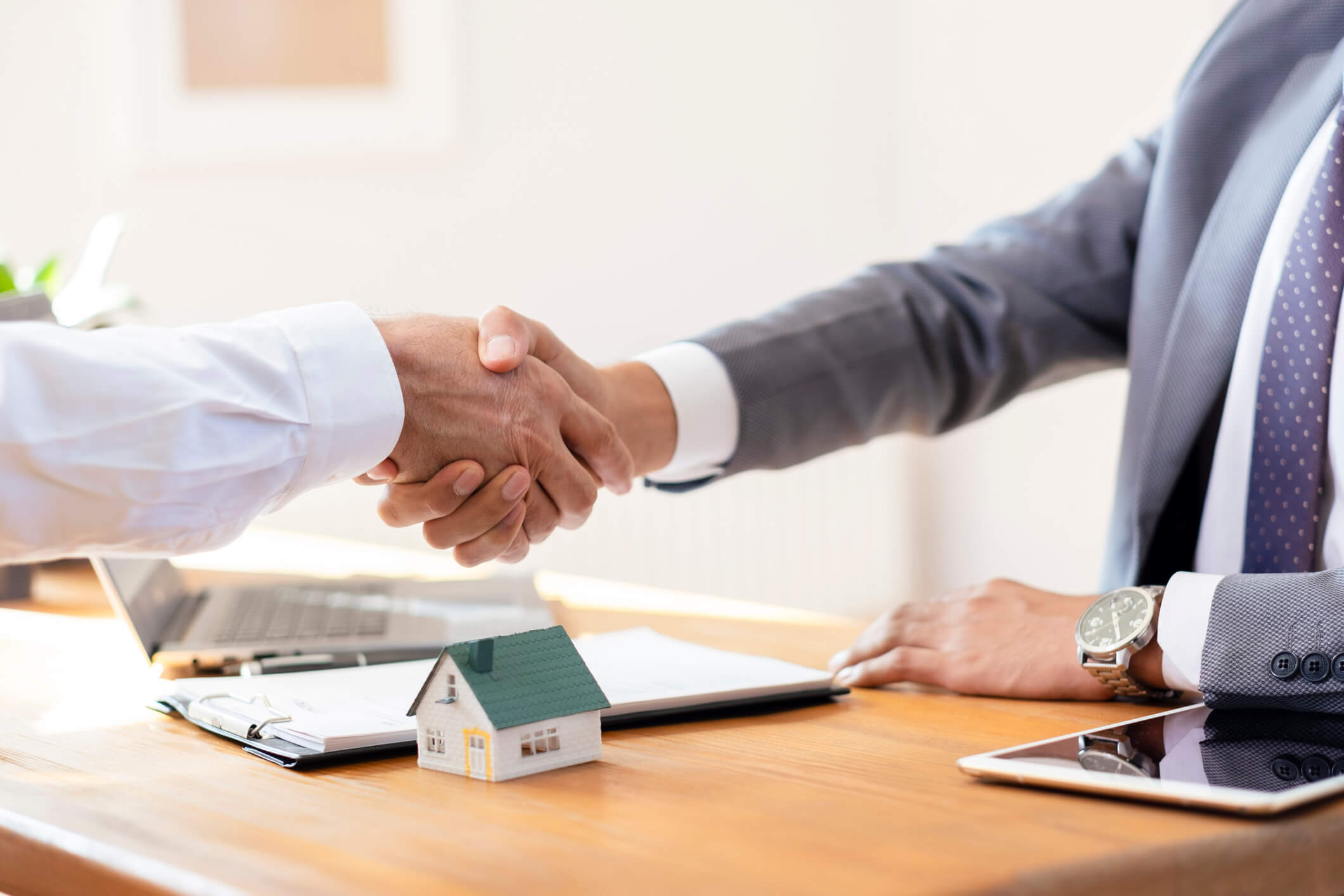 Business handshake over real estate contract