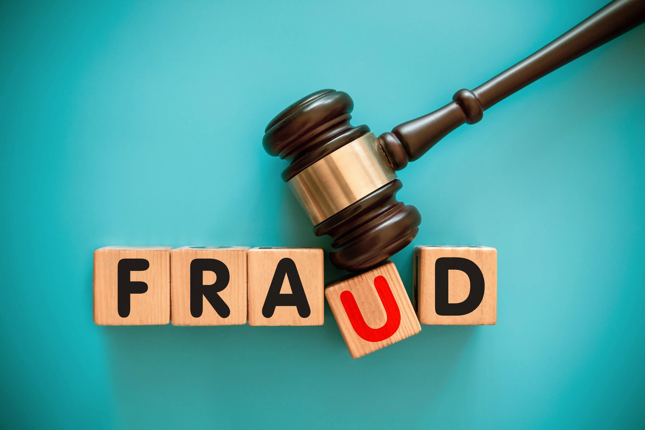 Wooden blocks spelling fraud with gavel