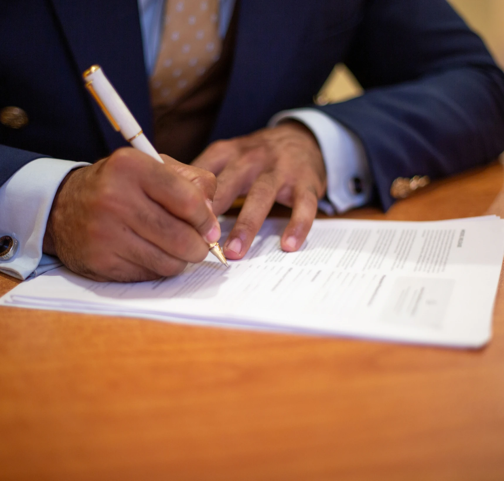 Professional signing paperwork at desk